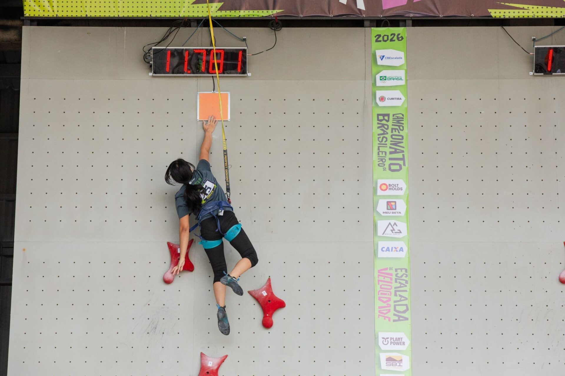 Atletas disputam escalada de velocidade em parede de 15 metros durante competição esportiva